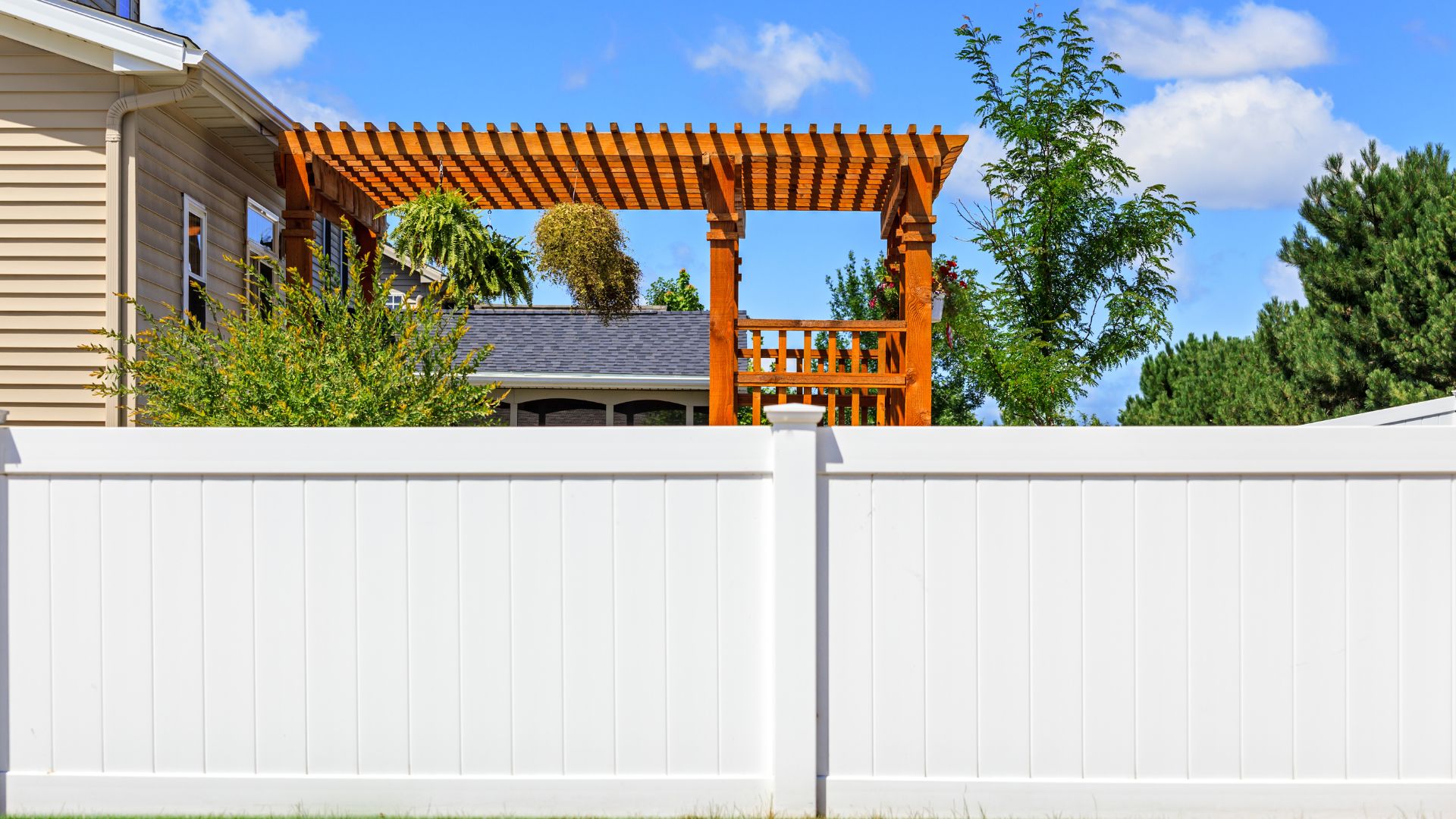 A white fence with a wooden structure in the background